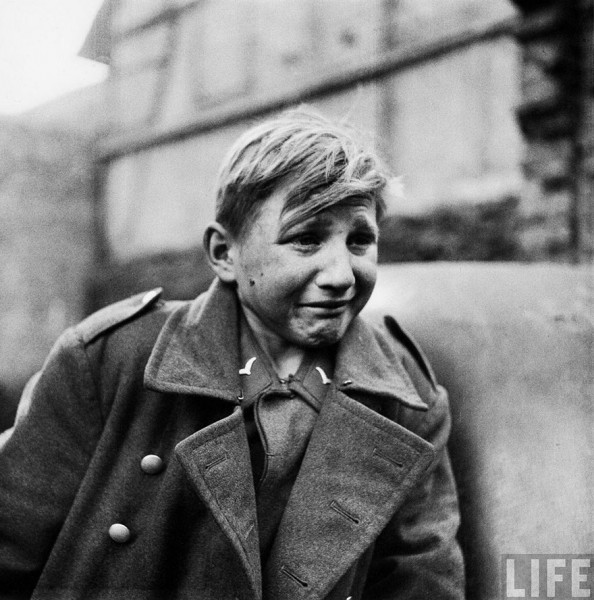 Un soldado alemán de 15 años, Hans-Georg Henke, llora después de ser capturado por la 9º armada de los Estados Unidos en Rechtenbach, Alemania, el 3 de abril de 1945. Él, quien rompe a llorar cuando su mundo se derrumba a su alrededor, era un miembro del Escuadrón antiaéreo Luftwaffe (Flackhelfer). Su padre murió en 1938 y su madre en 1944. Él se alistó en el Luftwaffe para mantenerse a sí mismo.